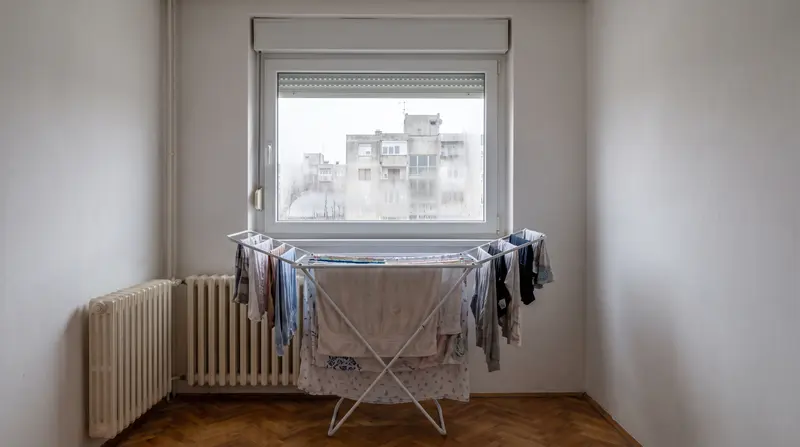 Sušilo puno rublja uz radijator u maloj sobi, prozor orošen pri dnu